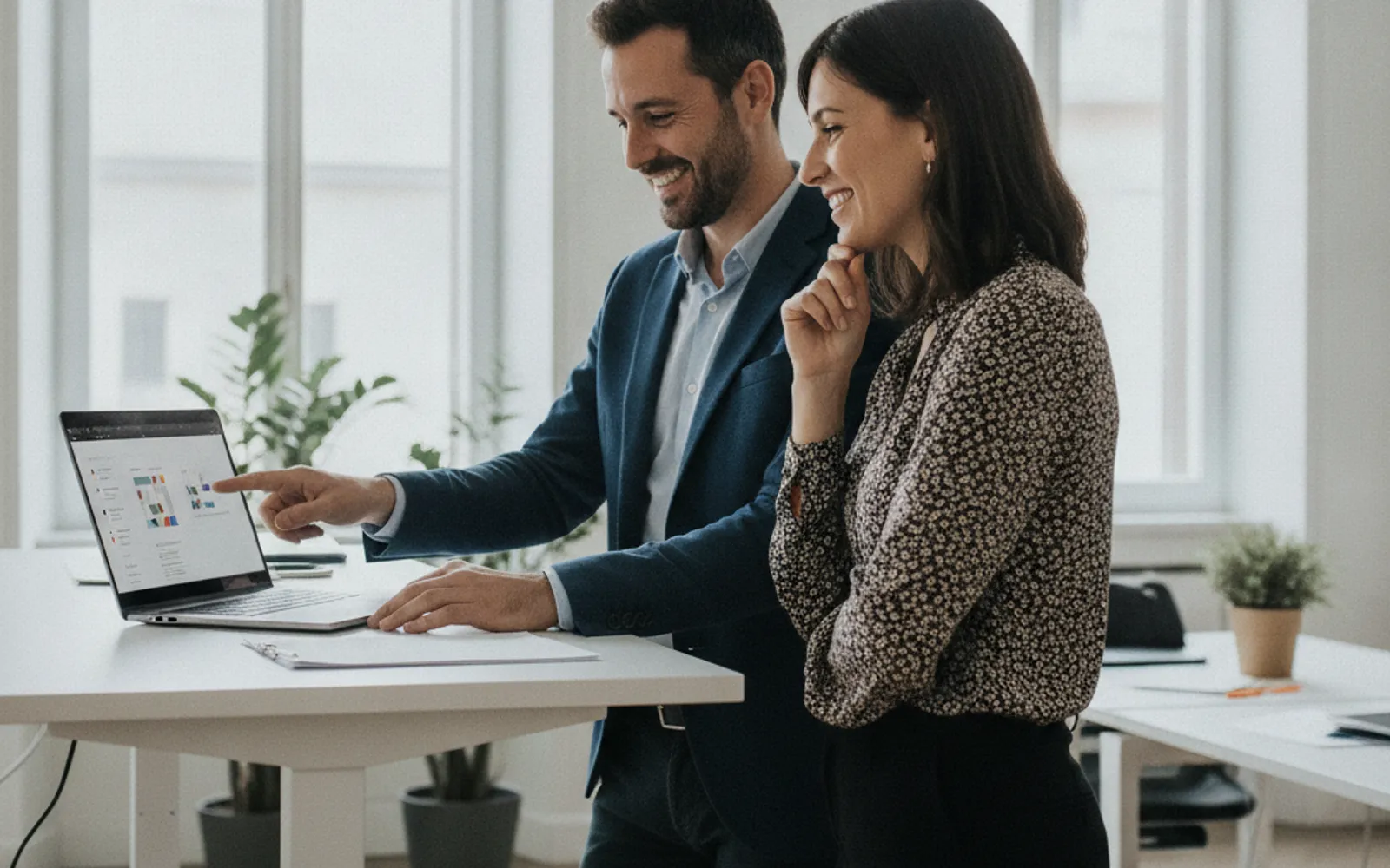 Agente di commercio e collega al lavoro su un portatile in un ufficio moderno
